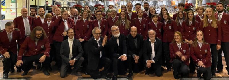 La consegna della targa per i 30 anni di direzione alla maestra Sara Mangaretto e, a destra, La Filarmonica di Verrès con la Banda Osiris al concerto di sabato scorso, 24 novembre