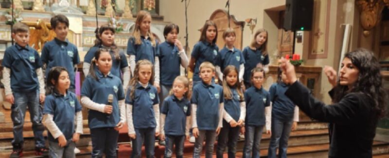 Il coro ChantEnvers con i coristi attuali e degli anni scorsi con, in prima fila, la direttrice Veronica Pederzolli e il primo direttore e fondatore Fabrizio Engaz. A destra il coro Petit ChantEnvers