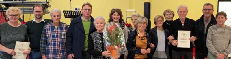 La premiazione dei più anziani presenti alla festa. Sotto, da sinistra, il sindaco Marco Sucquet e l’assessore Martine Peretto mentre omaggiano le due signore più anziane del paese: Ada Maria Soudaz di 103 anni (con dietro il nipote Leonardo De Gasper) e Linda Brunazzo di 101 anni