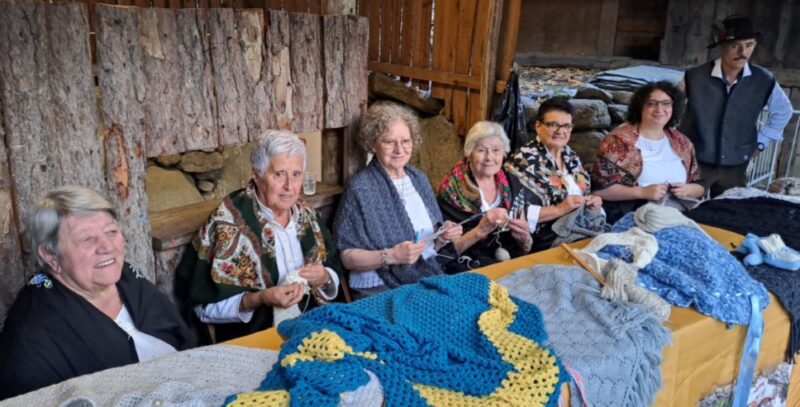 Le signore che lavorano la lana a maglia - da sinistra Stella Costabloz, Domenica Donini, Adriana Lateltin, Evelina Champurney, Graziella Bonin, e Camilla Seziam - con Patrick Dublanc