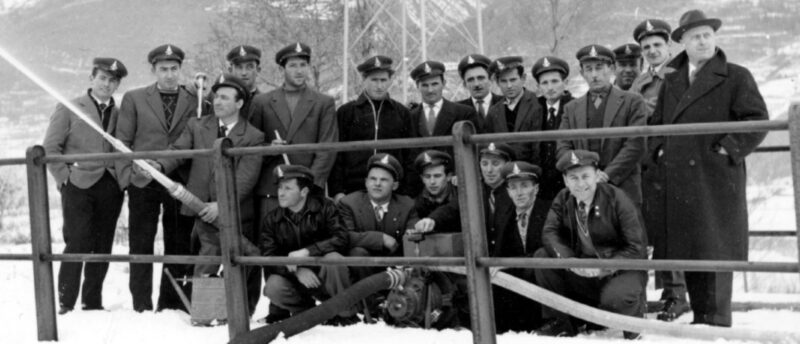 Nel 1960 i Vigili del Fuoco volontari di Brissogne con la nuova pompa: in piedi da sinistra Cesare Piassot, Pierino Bionaz, Alessandro Marcoz, Lino Champion, Elviro Bionaz, Stefano Jacod, Valentino “Renzo” Brunod, Angelo Deval, Valentino Marcoz, Silvio Marcoz, Pietro Verraz, Mirando Perruquet, Rico Marcoz e il fornitore della motopompa Giuseppe Gerbore; in basso Emiliano Carral, Augusto “Bino” Brunod, Valentino Zulian, Giulio Nouchy, Giuseppe Friolin e Giuseppe Perruquet