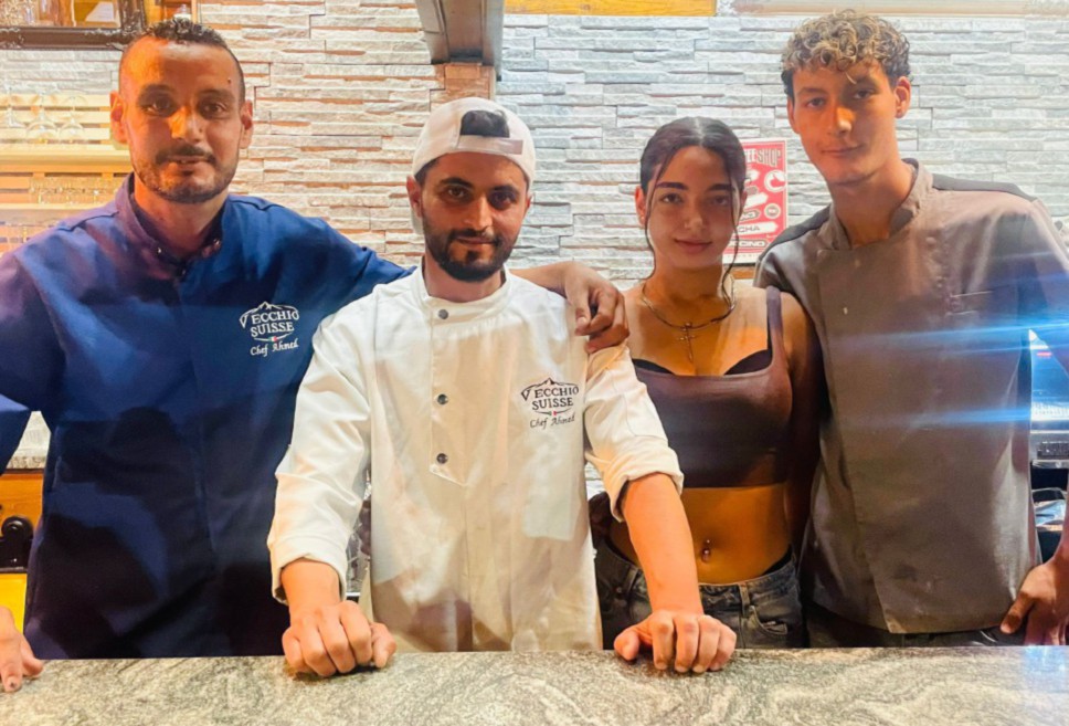 Da sinistra i due soci Ahmed Sadmi e Ahmed Rabit, Sofia Greco e Ilyas Sadmi dietro il bancone del Suisse Pub a Les Prailles di Valpelline